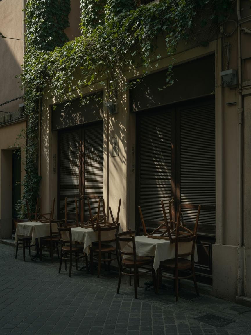 Terraza de restaurante cerrada con sillas apiladas y persianas bajadas, símbolo de pérdida de visibilidad y clientes